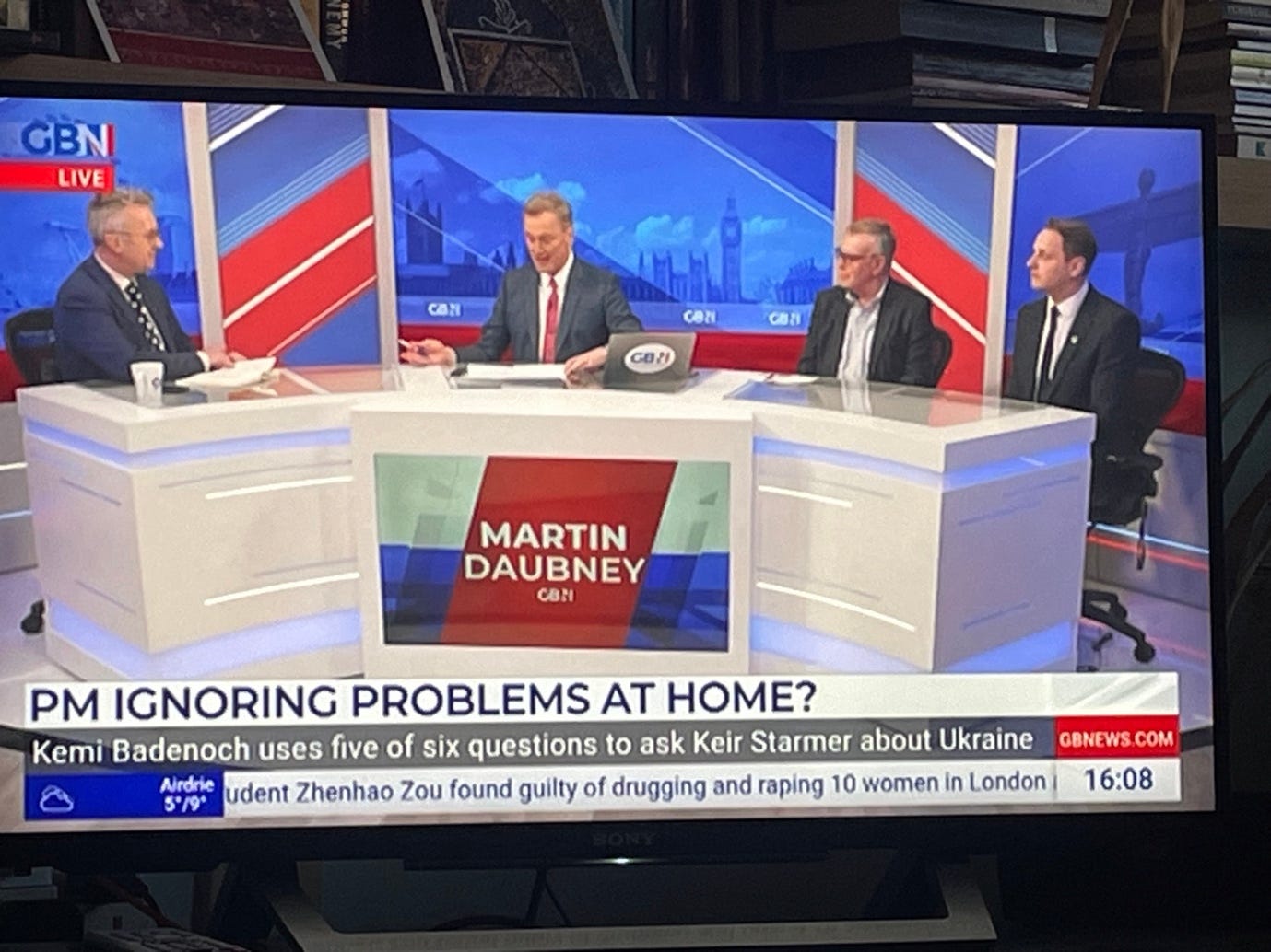 A television screen with men sitting at a table

Description automatically generated