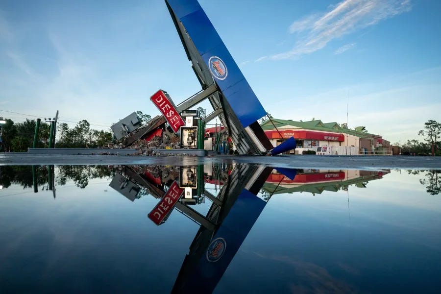 A storm-damaged gas station is reflected in a puddle after Hurricane Idalia crossed the state on August 30, 2023 in Perry, Florida. The storm made landfall at Keaton Beach, Florida as a category 3 hurricane. (Photo by Sean Rayford/Getty Images)