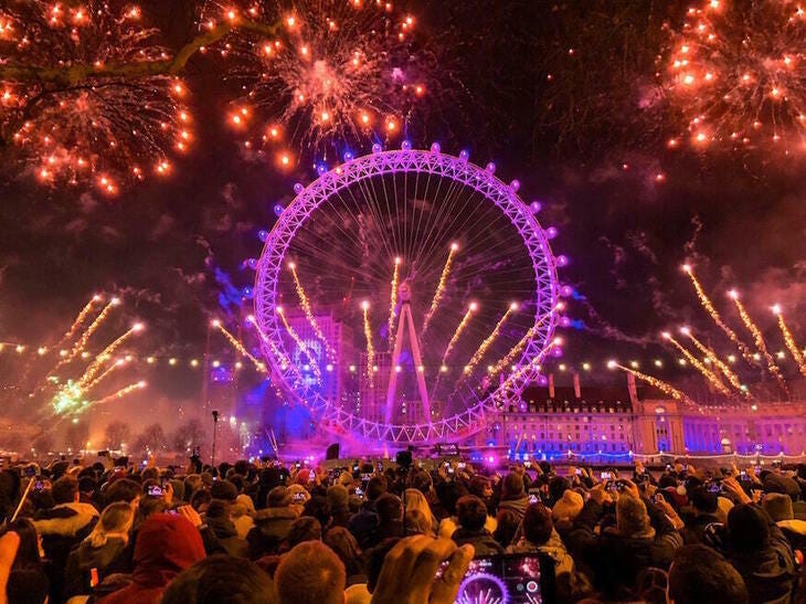 Fireworks going off around a pink London Eye