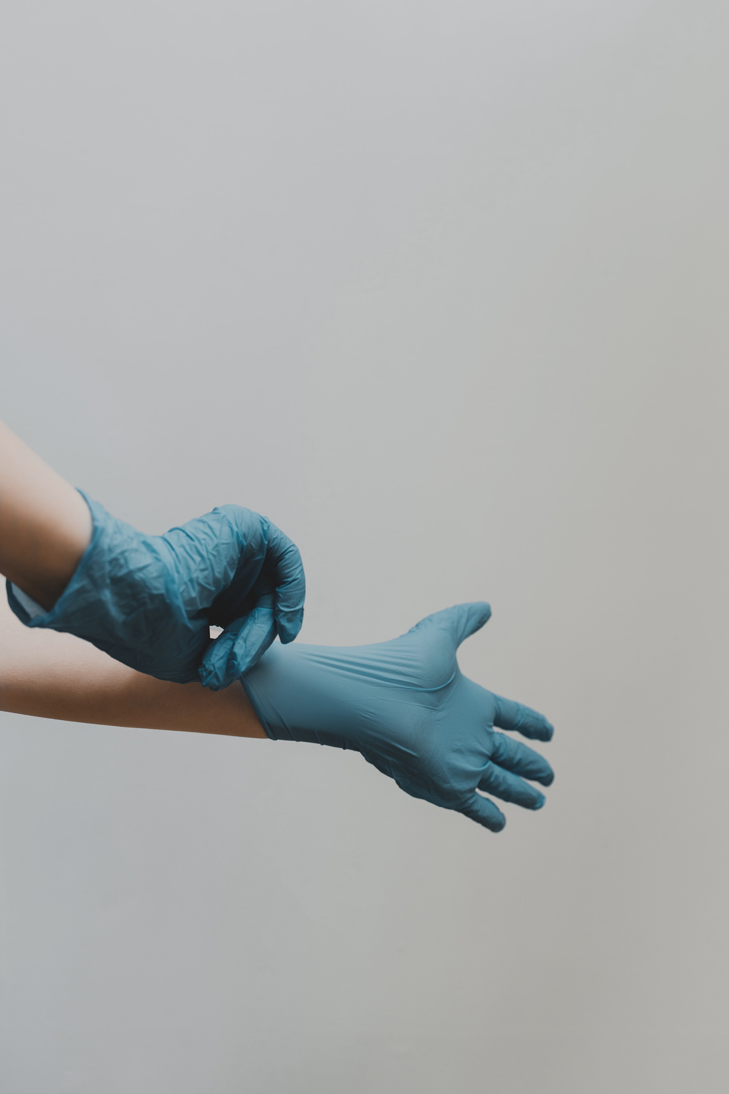 hands in blue medical gloves