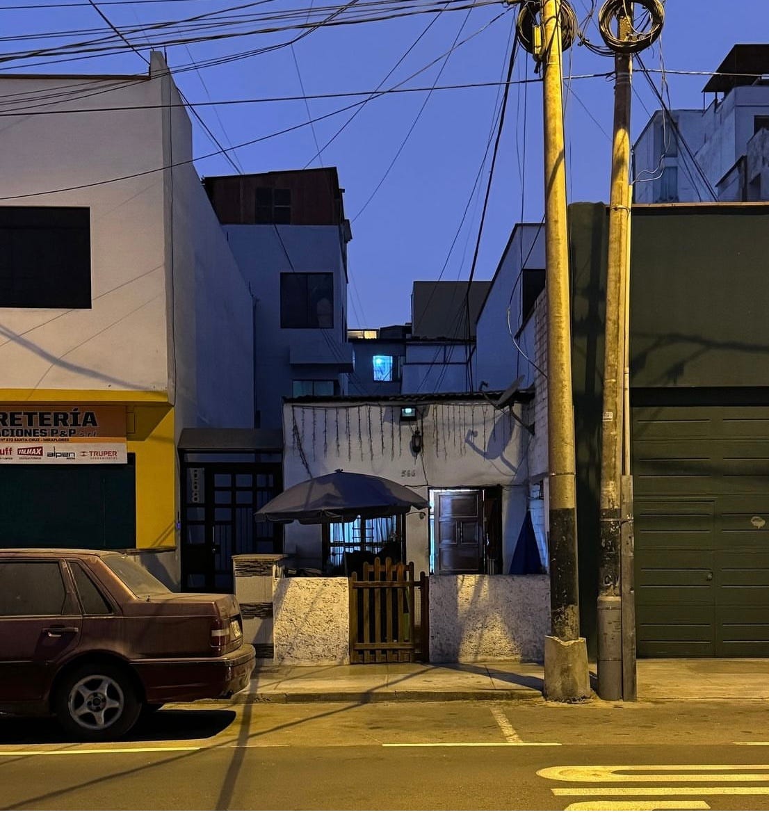 Small single family home lodged between two-story buildings