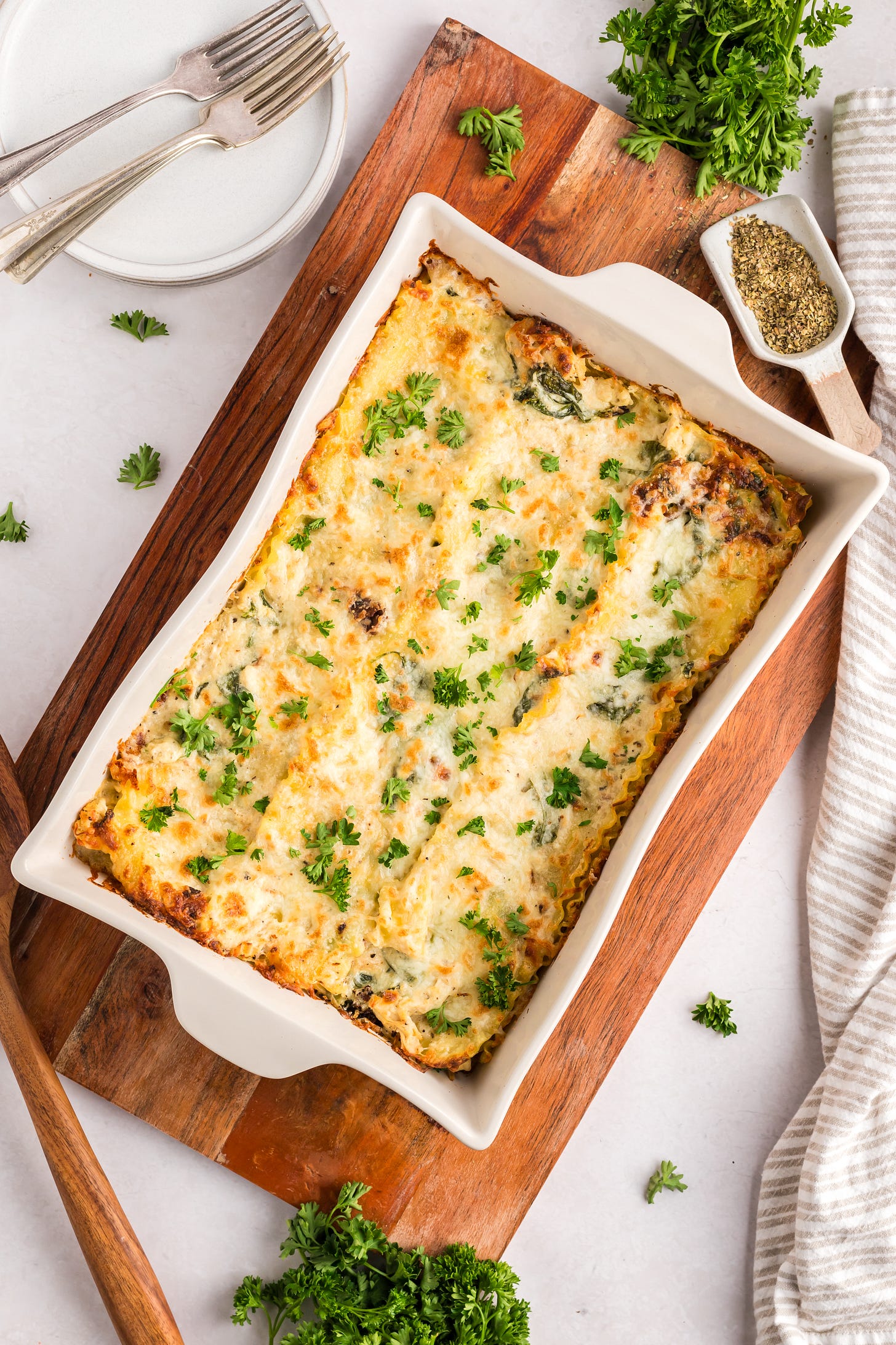 A casserole dish of chicken alfredo lasagna on a cutting board.