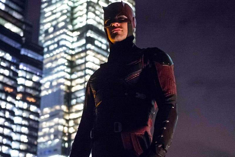 Picture of actor Charlie Cox playing Daredevil in the Netflix & Marvel TV series - stood in his dark red armoured costume against the New York skyline.