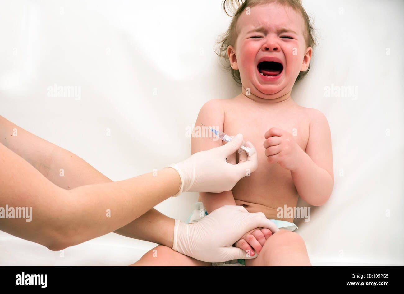 Syringe and crying baby injection in arm Stock Photo - Alamy