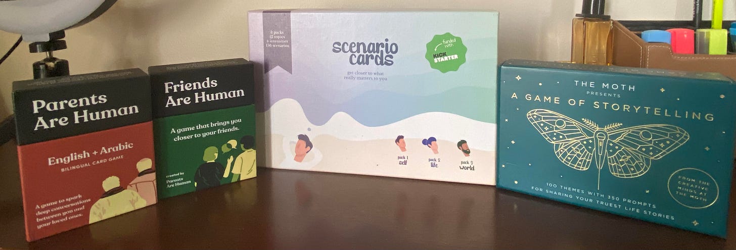 Photo of 4 boxes of decks of cards. From left to right the decks are named as followed: "Parents Are Human," "Friends are Human," "Scenario Cards" and "The Moth Story Cards"