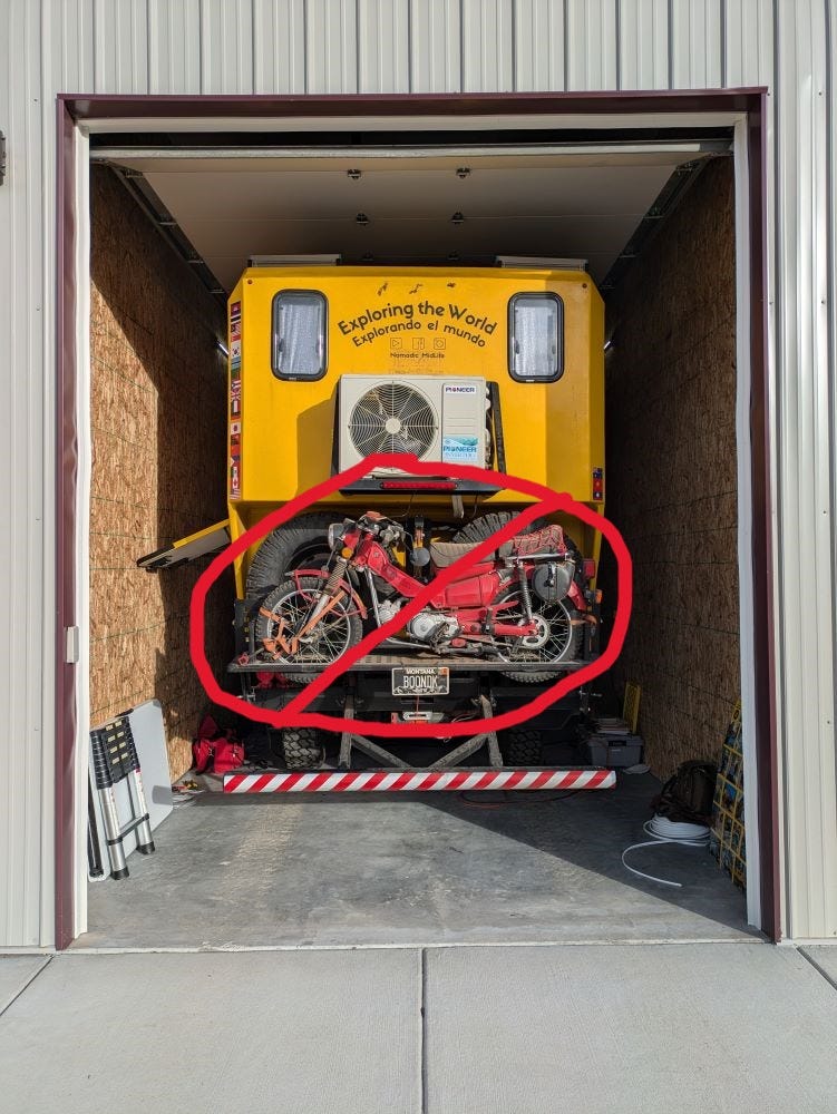 Walter the big yellow truck is tucked snugly into a storage unit. The motorcycle on the back has a red circle around it with a line through it, indicating that it is being cut out.