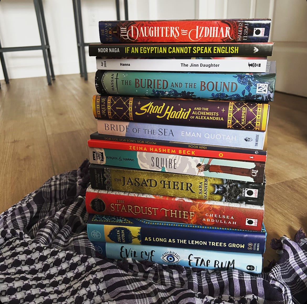 A stack of books by Arab authors. A full list of titles is below.
