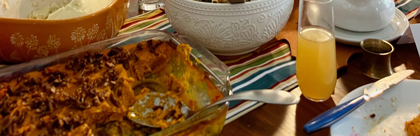 a snippet of the chaos of a table: sweet potato casserole and assorted dishes