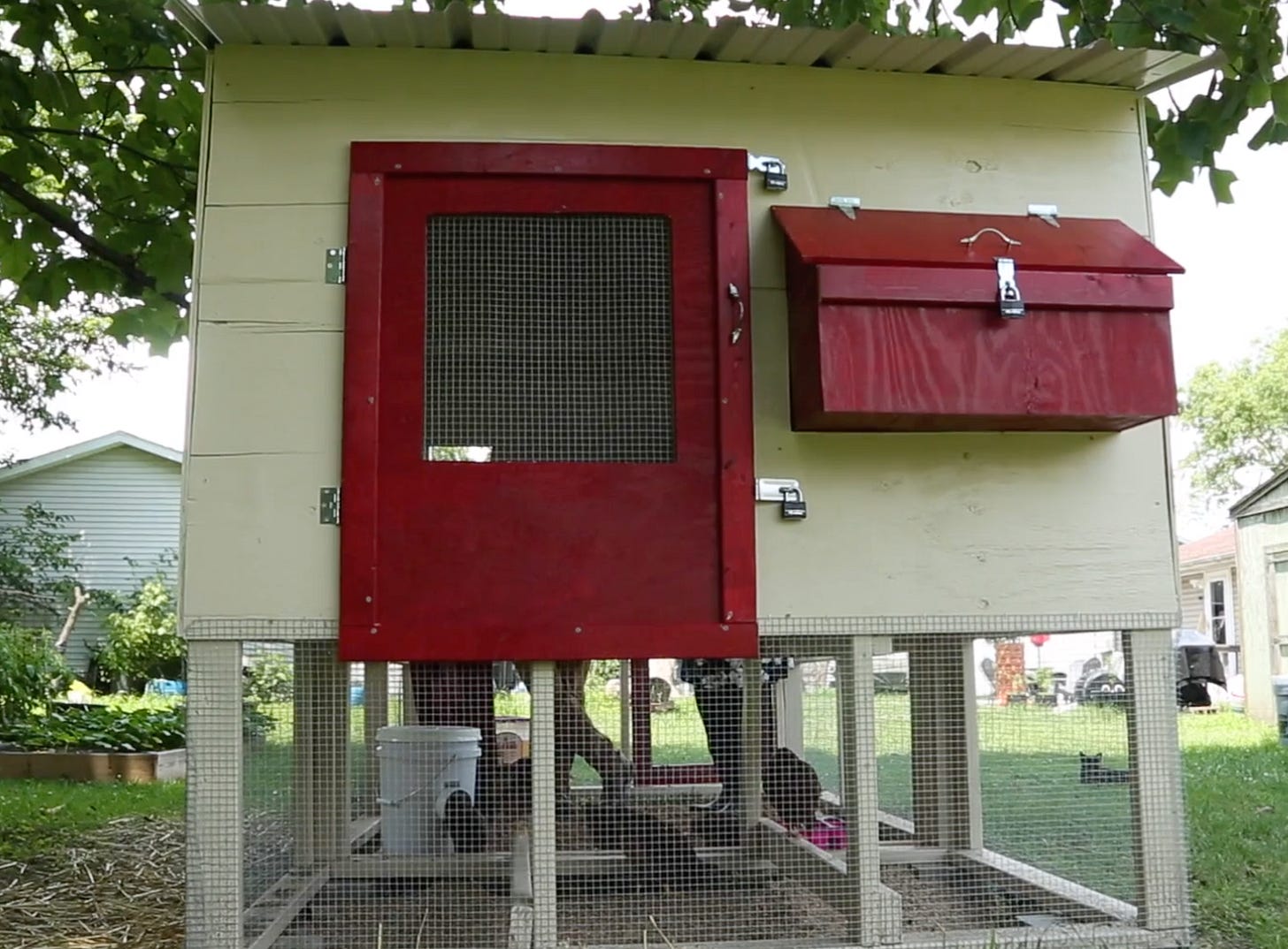 a finished chicken coop with white paneling and red accents