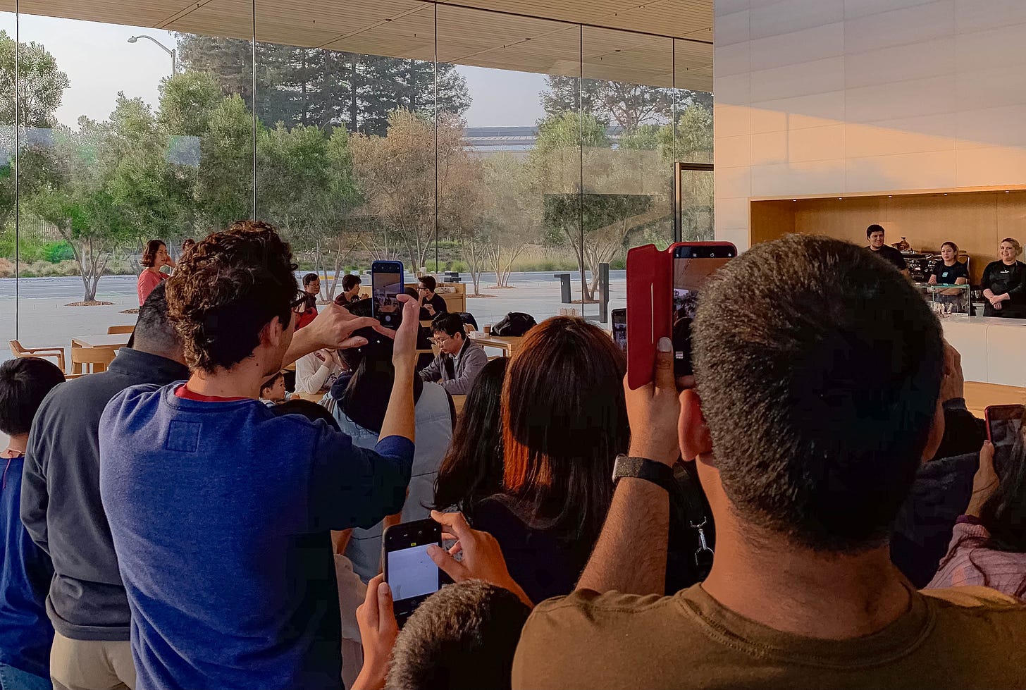People at Apple Park Visitor Center shoot photos in the cafe during a Today at Apple Photo Walk.