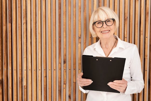 Free Photo | Old woman with a clipboard on wooden background