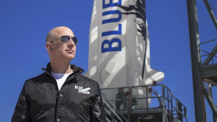 Blue Origin's Jeff Bezos standing in front of rocket