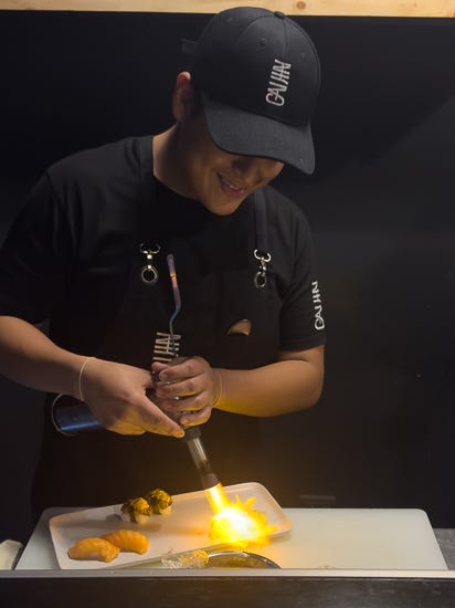Chef at Tomo flambees the nigiri with a torch, giving it a beautiful, charred flavor.