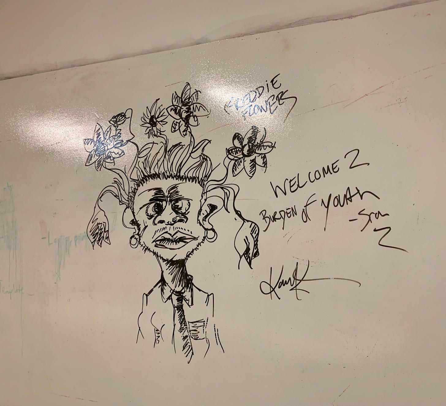 an illustrated image created on a whiteboard with a black dry erase marker. the image resembles a masculine-presenting character with flowers for hair. the character's face is expressionless and they're wearing a button up with a tie and hoop earrings. Character's name: Freddie Flowers. Add'l text reads: Welcome 2 Burden of Youth