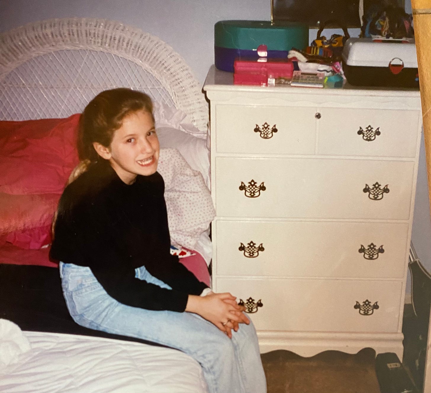 Eight year old girl smiling with braces, next to a white dresser.