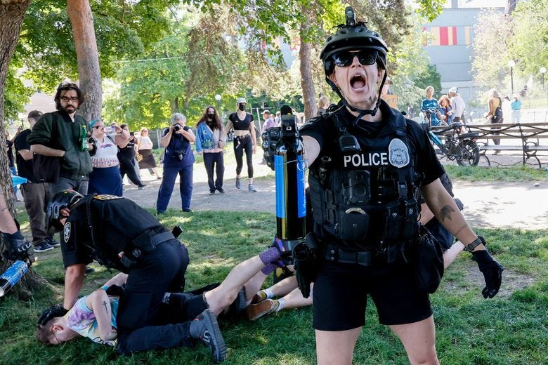 Seattle police arrest counterprotesters outside of the Mayday USA rally at Cal Anderson Park in Seattle’s Capitol Hill neighborhood on Saturday. (Jennifer Buchanan / The Seattle Times)