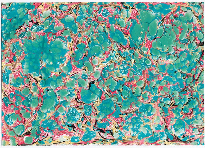 Marbled paint on paper in swirls of blue, green, red, and yellow