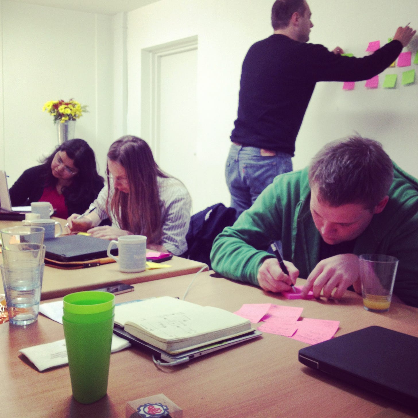 Picture of team hard at work writing sticky notes