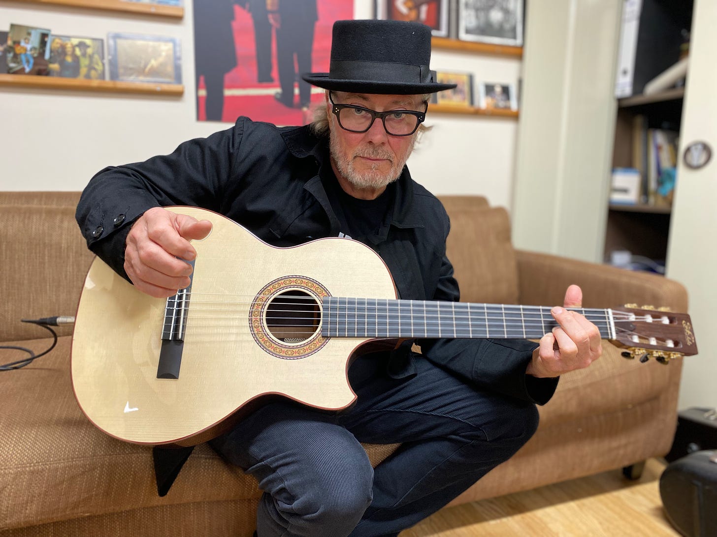 Simon Campbell holding his Fylde Classical in the reception area of Fylde guitars