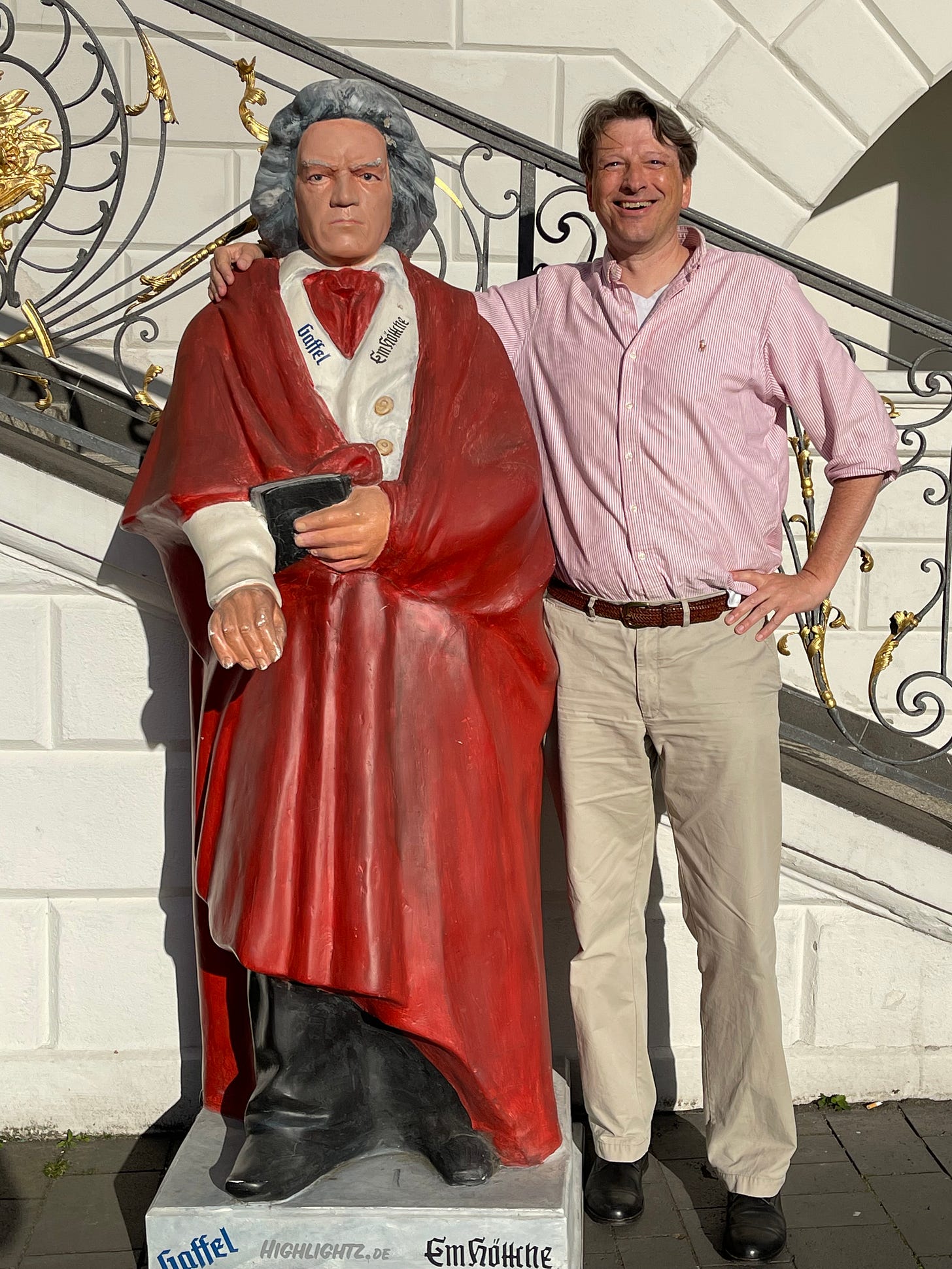 standing next to a statue of Beethoven