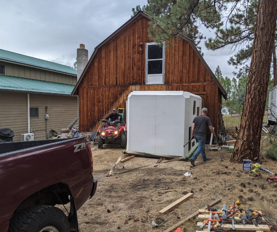 large white habitation box is pulled out of the small barn