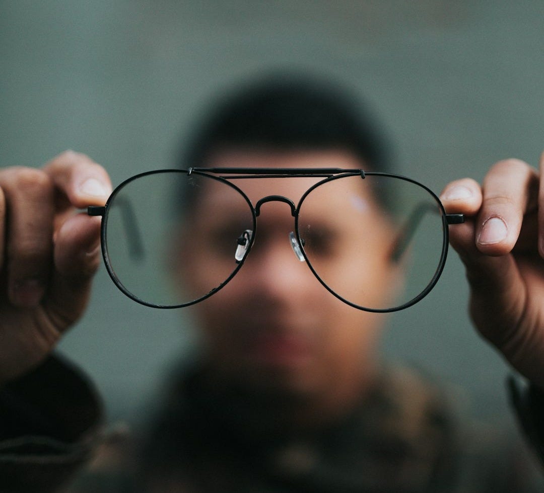 man holding eyeglasses man holding eyeglasses