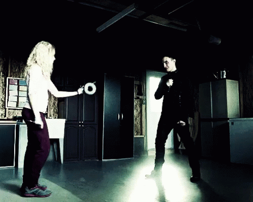 A woman drop-kicking a roll of duct tape into a man's face, an epic move from Orphan Black