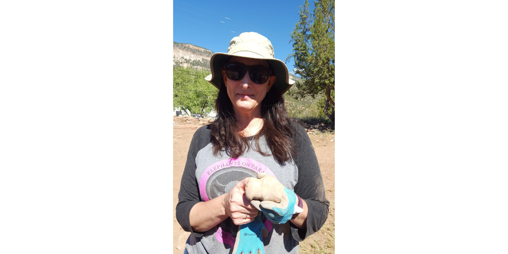 Me in my hat and sunglasses, holding the stone axe. It’s a roughly palm-sized light brown stone. The cutting edge of the axe is broken away, but the indentation where cording would have fastened it to a handle is clearly visible.