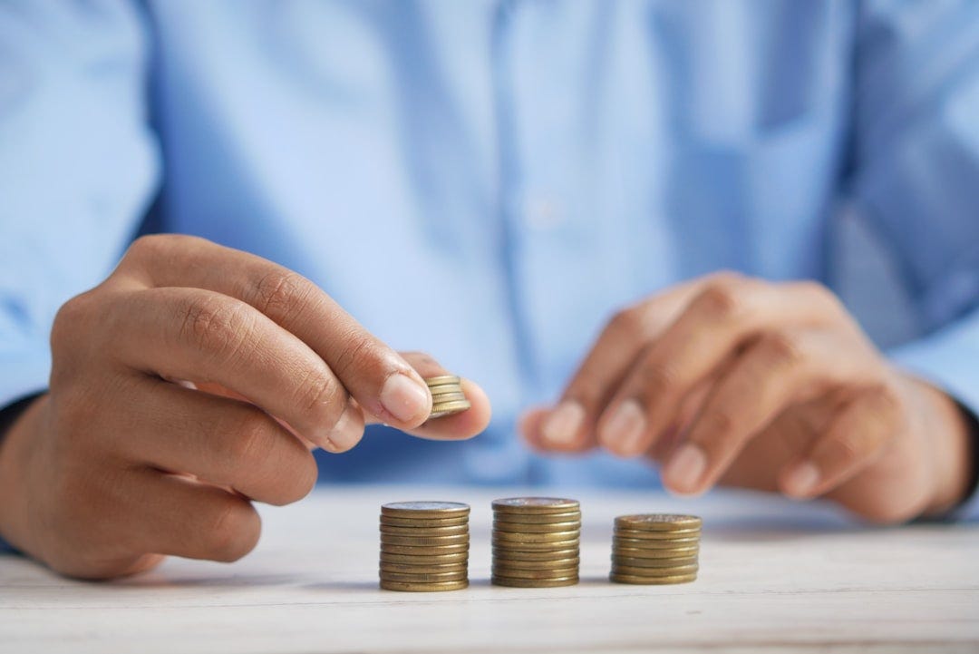 a person stacking coins on top of a table