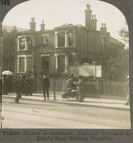 A black and white photo of an impressive detached house, made to look less impressive by the missing roof and blown out windows. The picture is taken from one-half of a stereoscopic 3-d image.