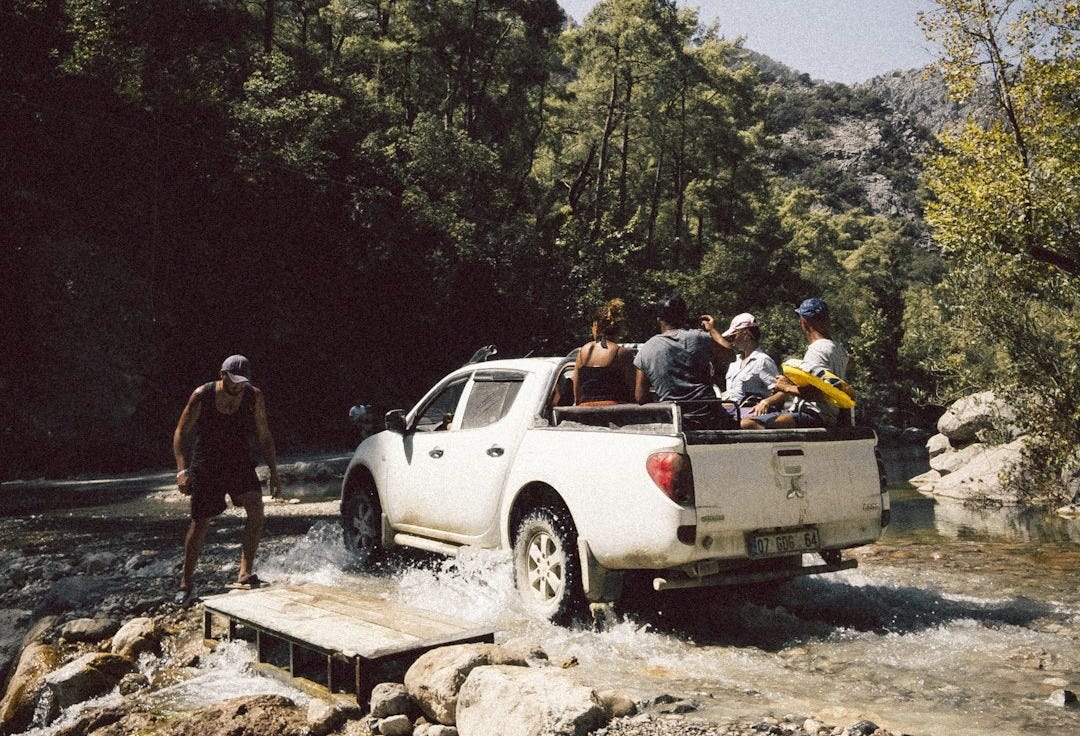 people standing beside white crew cab pickup truck during daytime