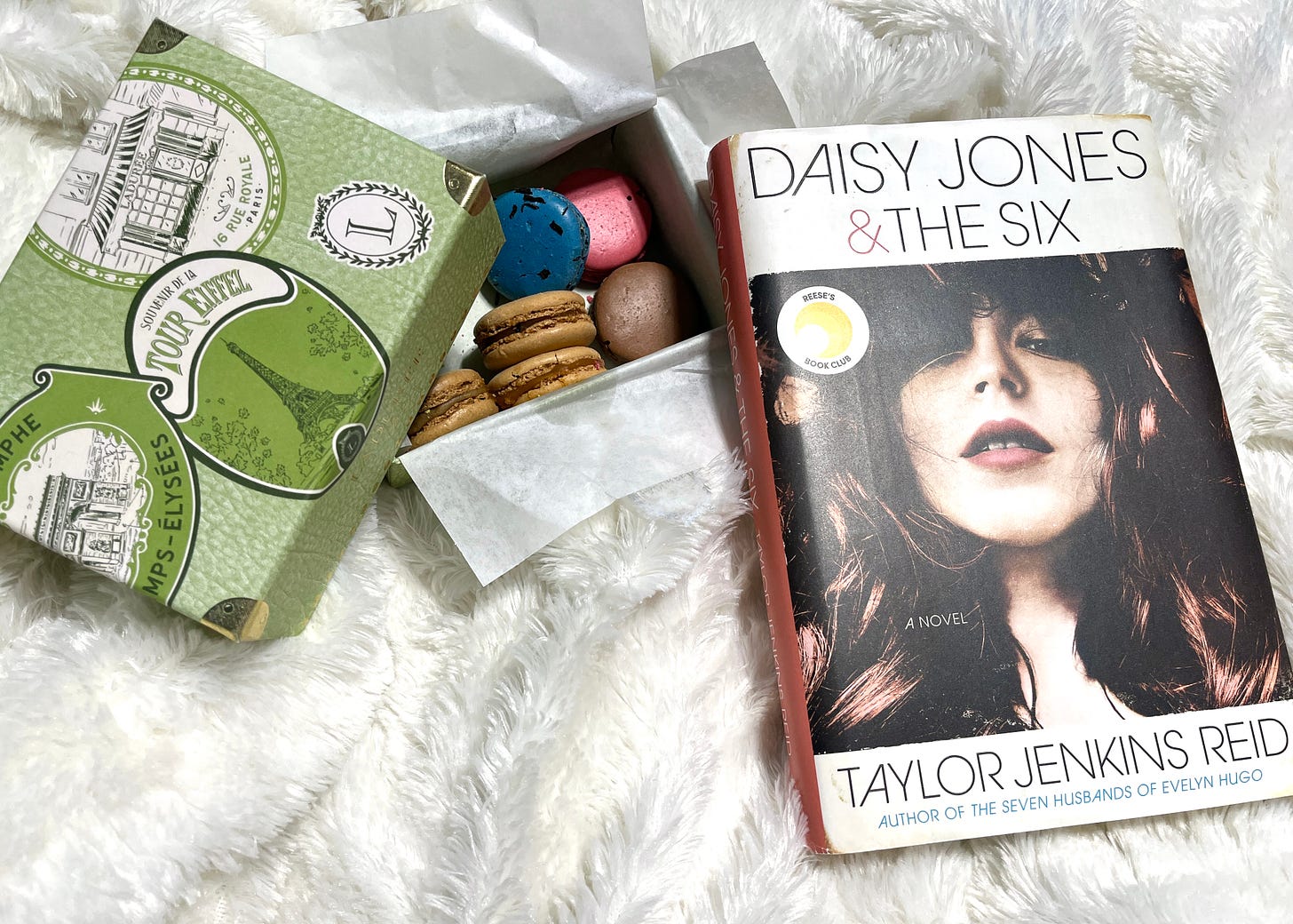 Daisy Jones and the Six with a box of macarons