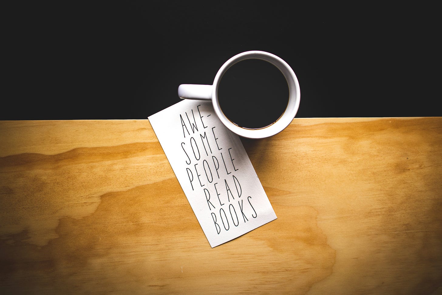 Image of a cup of coffee and a card that reads "awesome people read books"