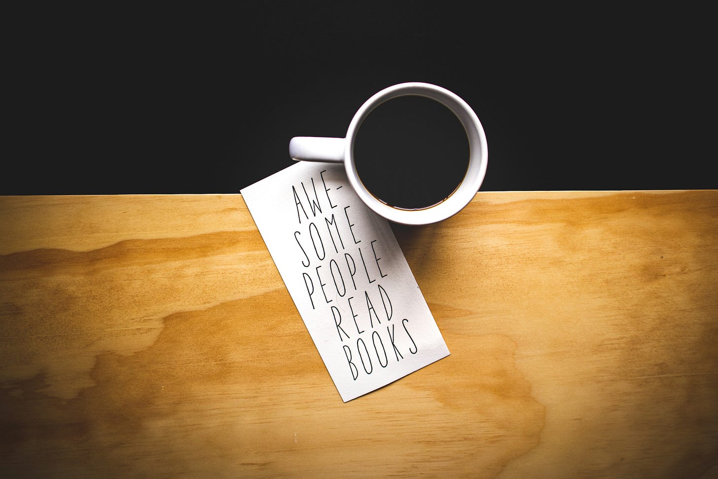 Image of a cup of coffee and a card that reads "awesome people read books"