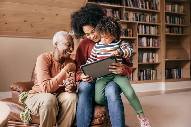 How Smart Home Tech Can Help Older Adults Three generation family sitting with tablet and laughing together rehabilitation technologies stock pictures, royalty-free photos & images