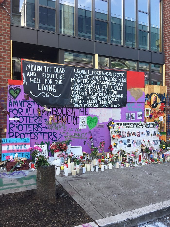 An image of multiple murals, signs and graffiti from Seattle’s CHAZ/CHOP protest zone in 2020. Signs say things like “Amnesty for all looters, rioters and protesters” and “Abolish the police” as well as memorials for Black people like George Floyd who had been killed by the police leading up to the protests.