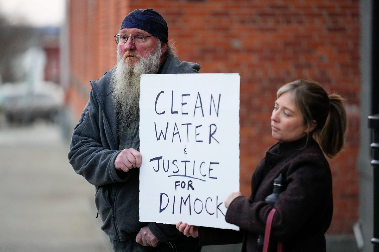 Ray Kemble (left), of Dimock, Pa., and Renee Vogelsang hold a sign outside the Susquehanna County Courthouse in Montrose, Pa., in 2022. Pennsylvania's most active gas driller, Houston-based Coterra Energy Inc., pleaded no contest to criminal environmental charges in a landmark pollution case.