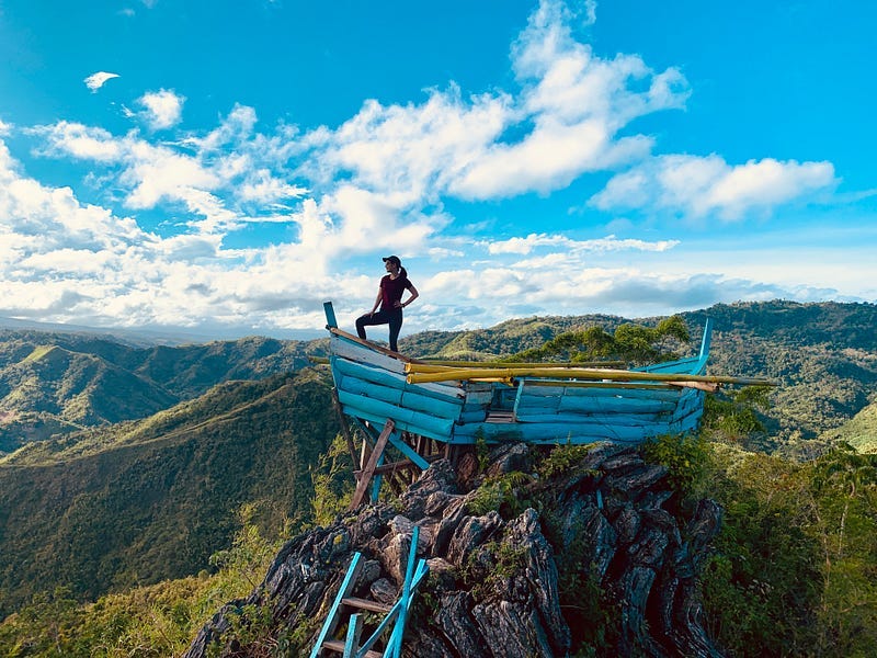 Girl posing in an ark on a mountain with a view of the sky