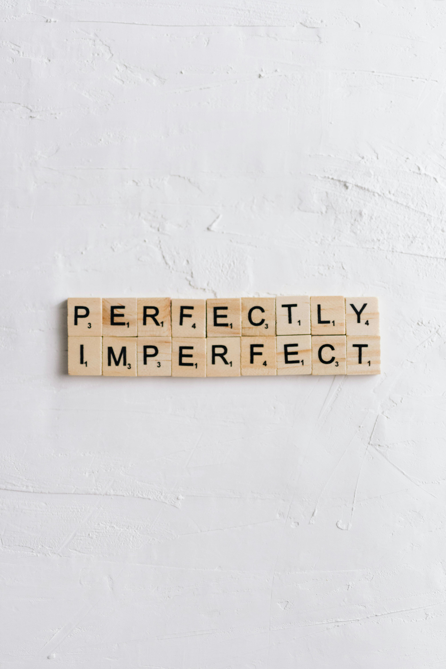 Scrabble tiles with the words "perfectly imperfect"