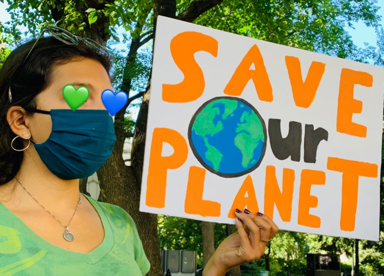 Photo of a protestor holding a "Save our planet" sign