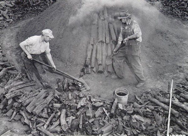 Old timers making charcoal in an earthen furnace