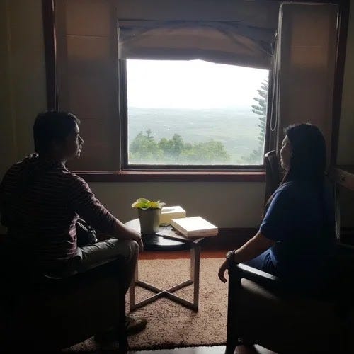 Silhouette of a couple looking outside the window