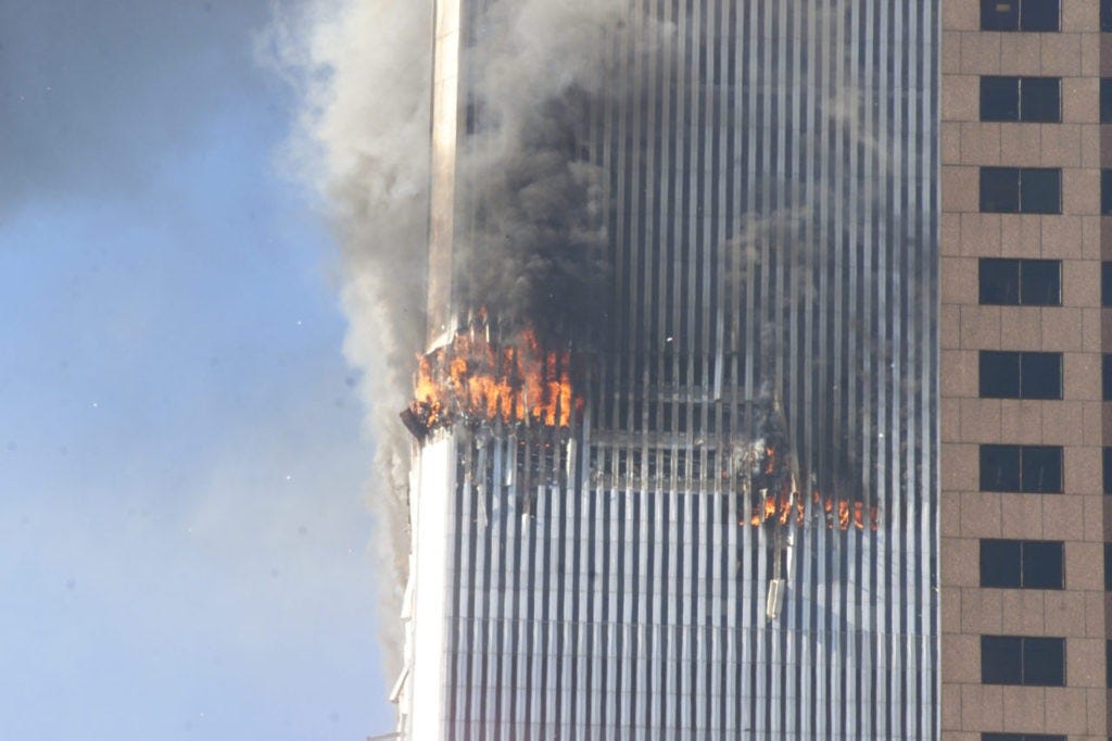 Debris fall from one of the burning twin towers of the World Trade Center after a hijacked plane crashed into the tower on September 11, 2001 in New York City.(AP Photo/Richard Drew)