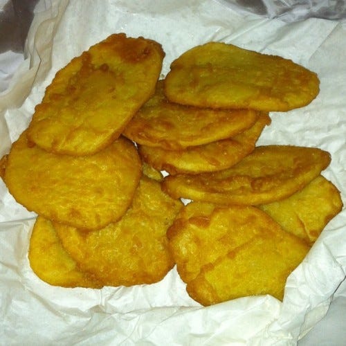 Thin slices of potato dipped in batter and deep fried in paper from the chip shop