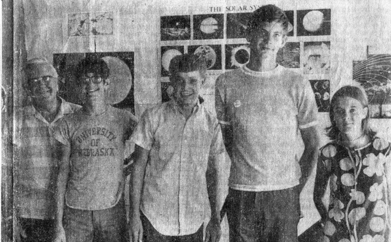 CCAOS at the county fair, 1970. One girl, 3 boys, and an older man standing in front of a wall of astronomy posters.