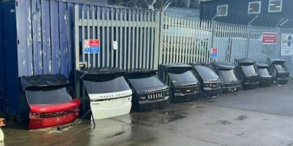 Range Rover and other tailgates propped against a fence in a row