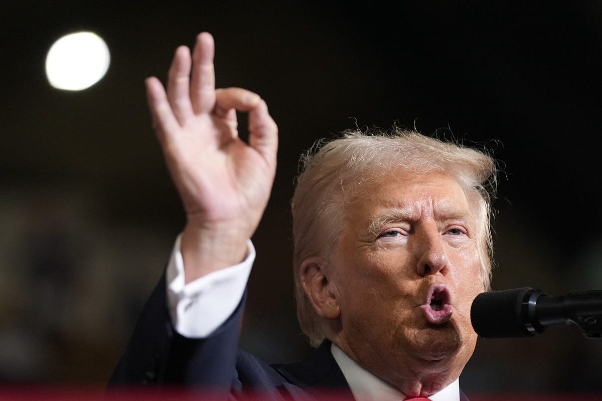 Trump speaking with anus-shaped mouth making white power symbol with hand