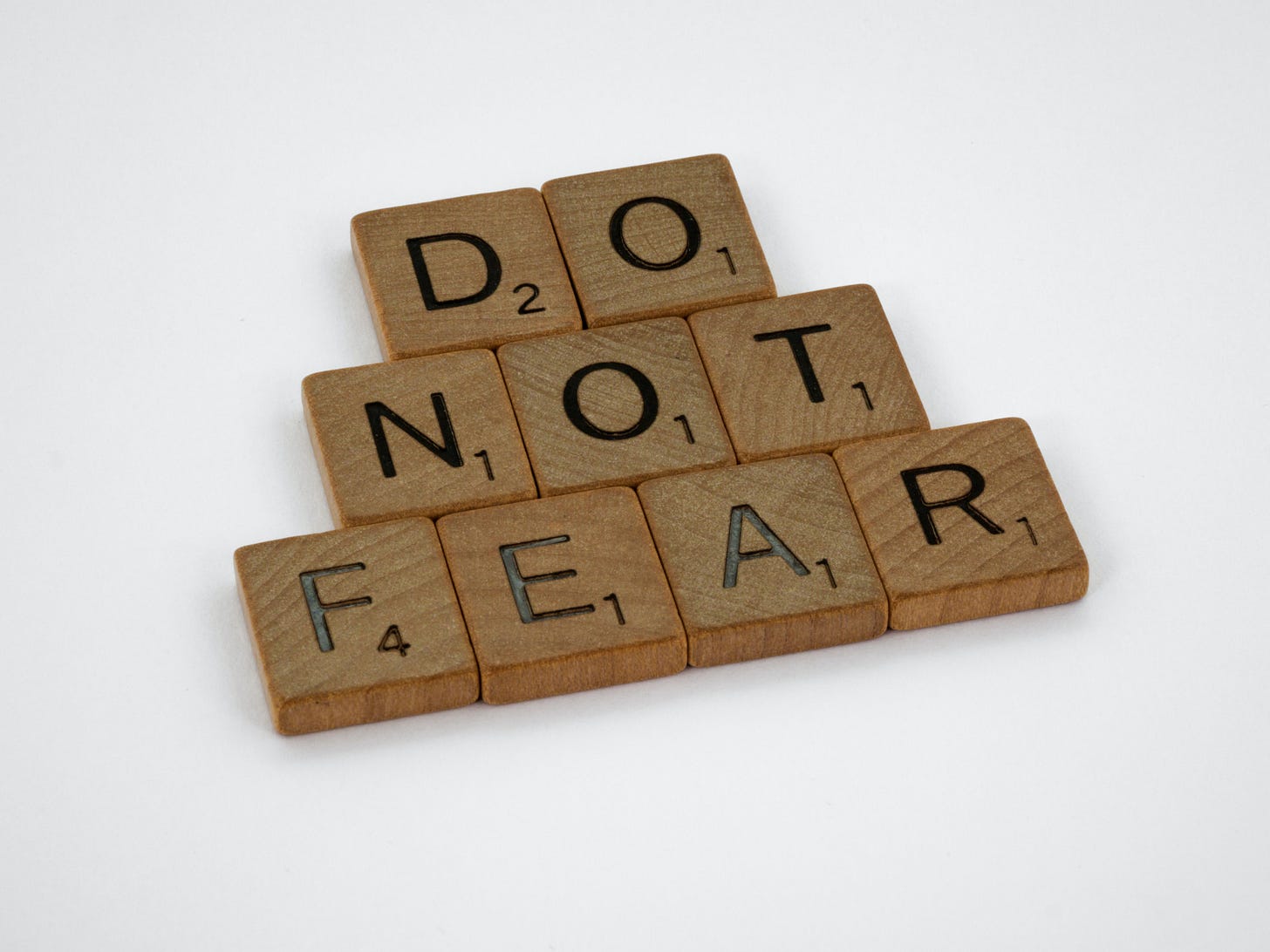 "Do not fear" written in Scrabble tiles set against a white background. "Do" is on the top row, "Not" in the middle row, and "Fear" is on the bottom row.