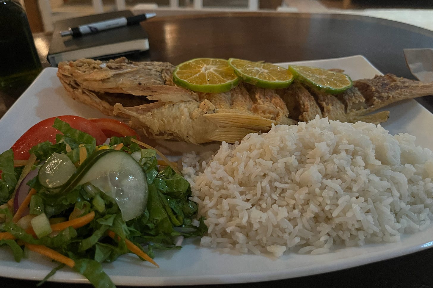 Fried snapper, salad, and white rice on plate.