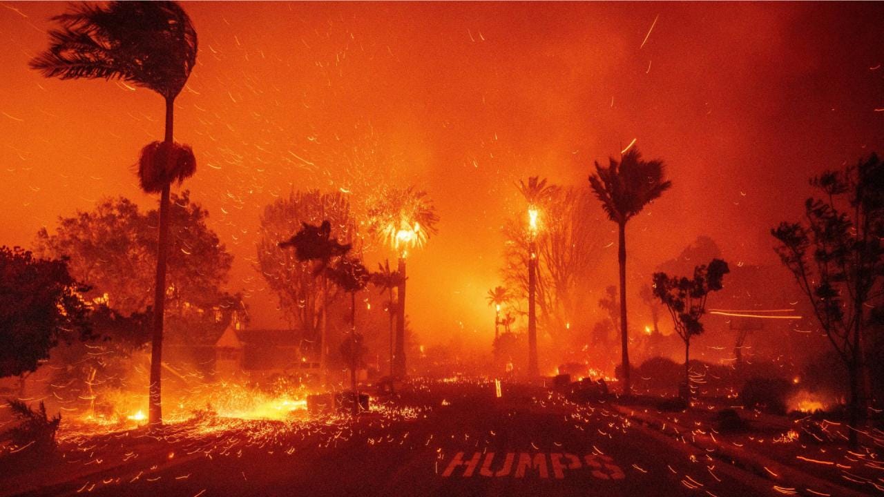 An urban street lined with palm trees on fire